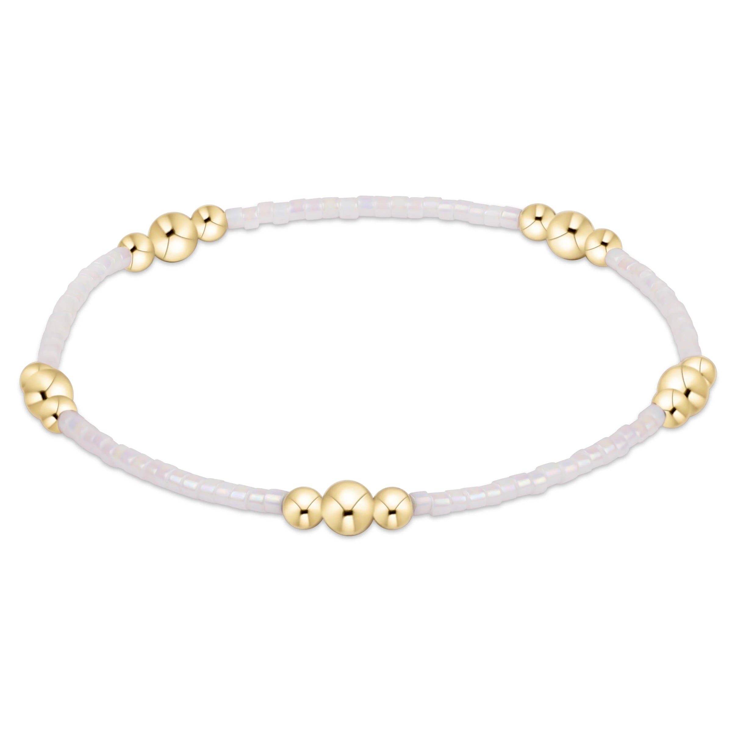 White bracelet with gold beads on a white background
