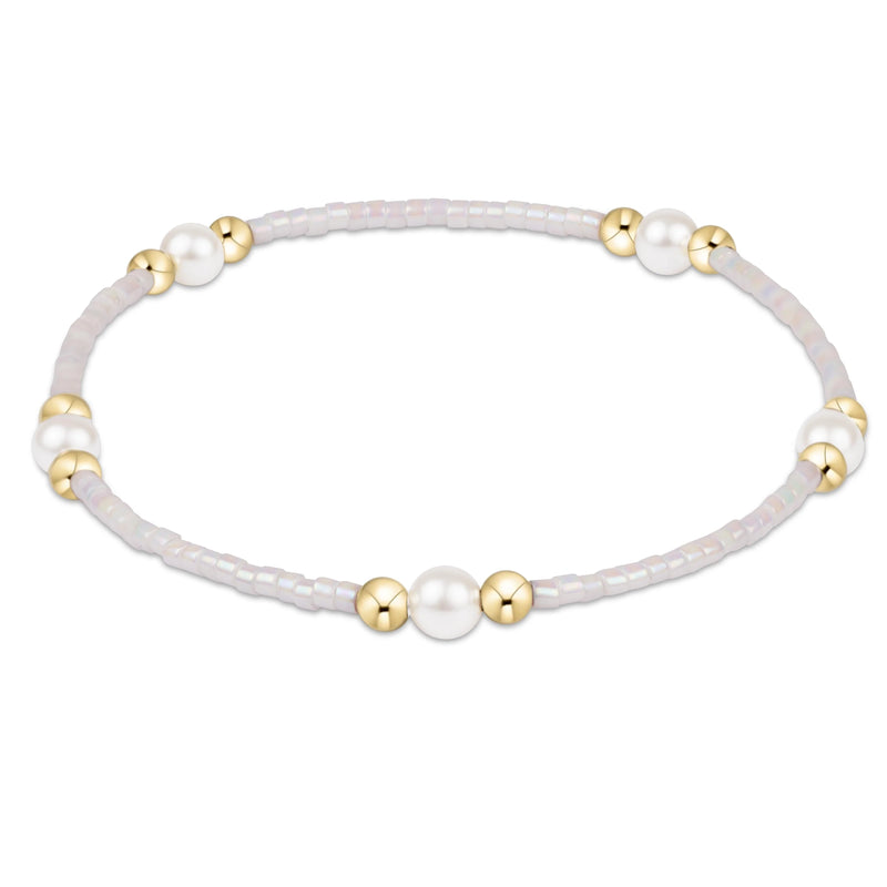 Bracelet with white beads and gold accents on a white background