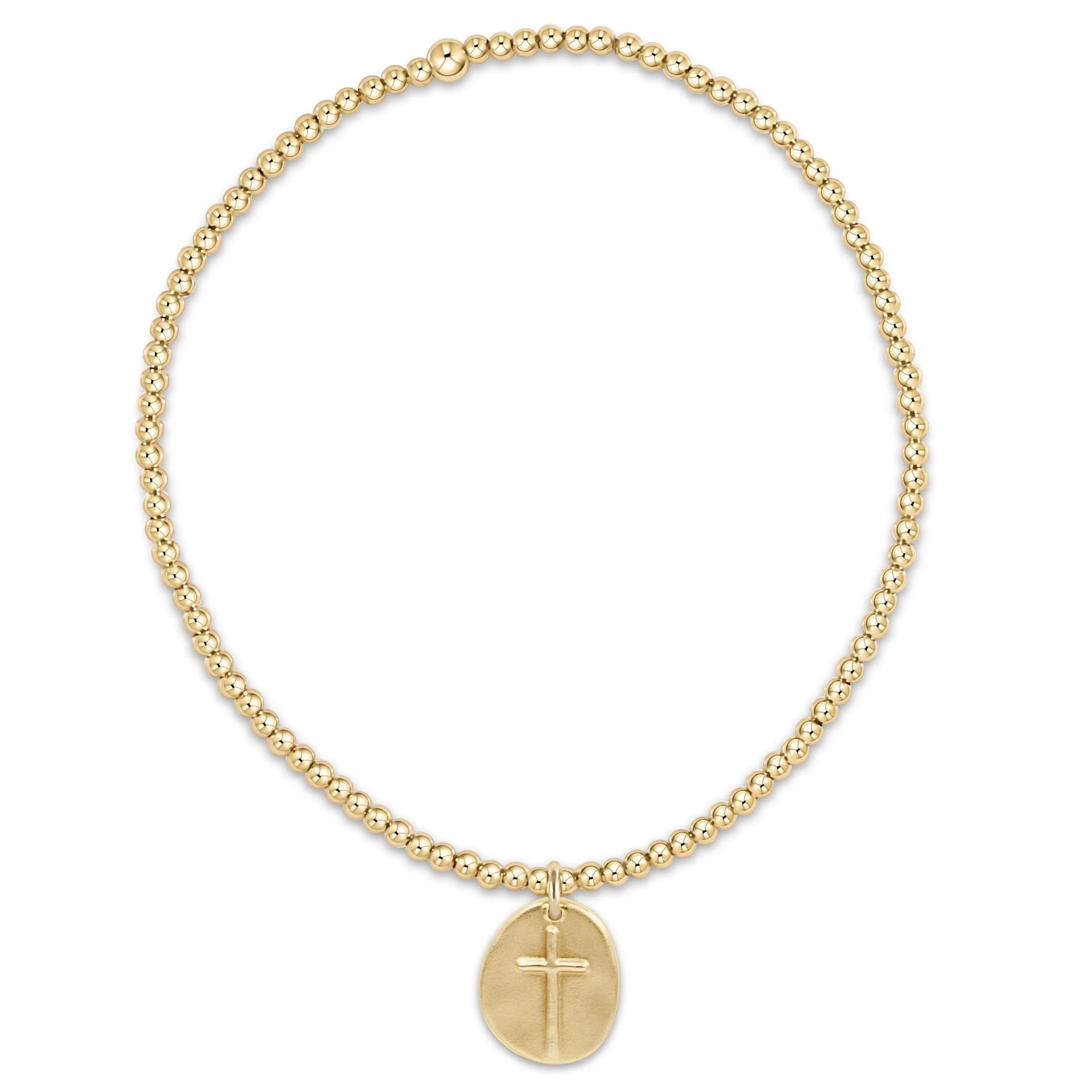 Gold beaded necklace with a cross pendant on a white background