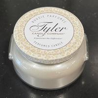 Grey candle with a decorative lid on a dark surface