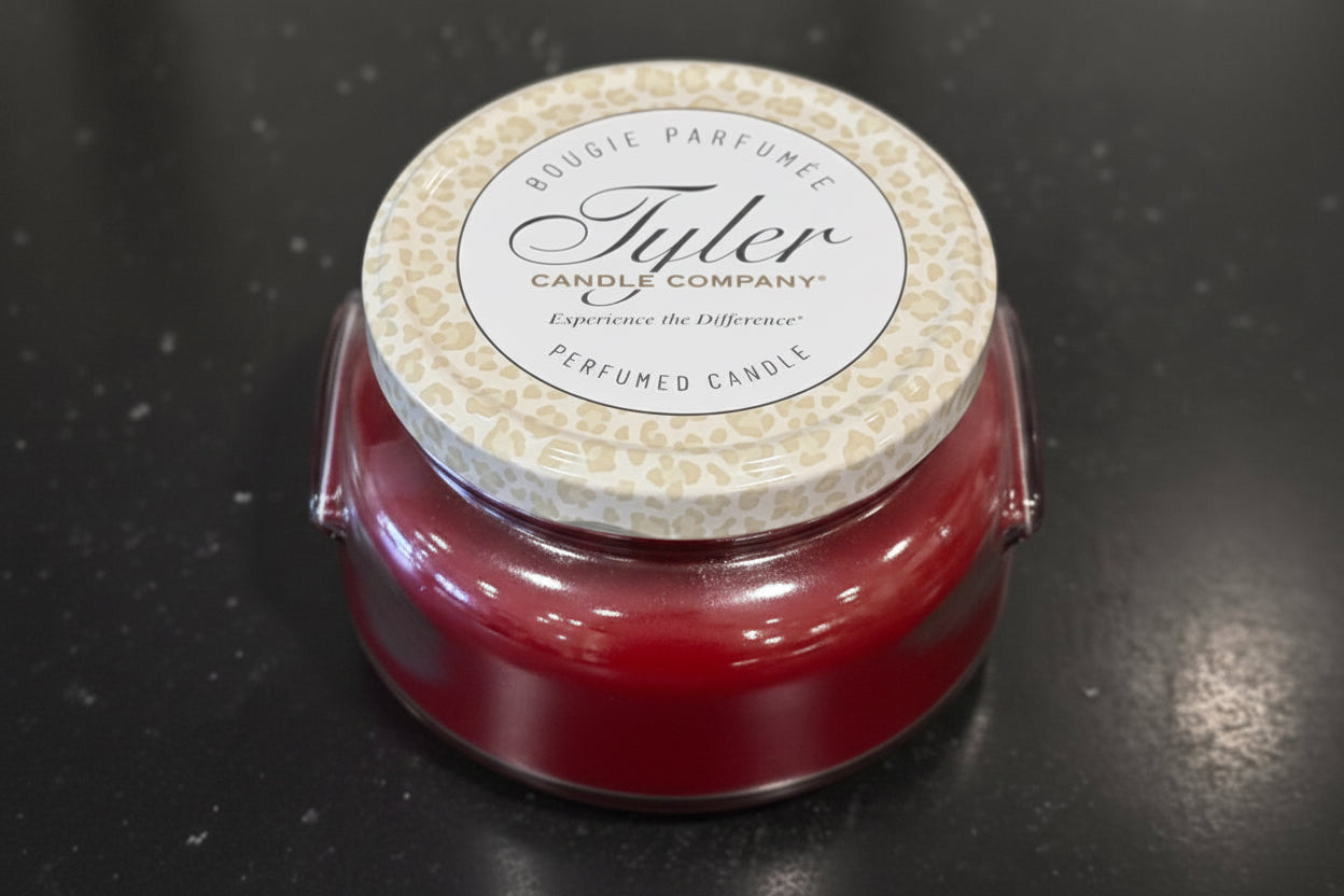 Tyler candle with a patterned lid on a dark surface