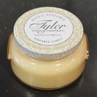 Tyler candle with a patterned lid on a dark surface