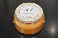 Tyler candle with a patterned lid on a dark surface