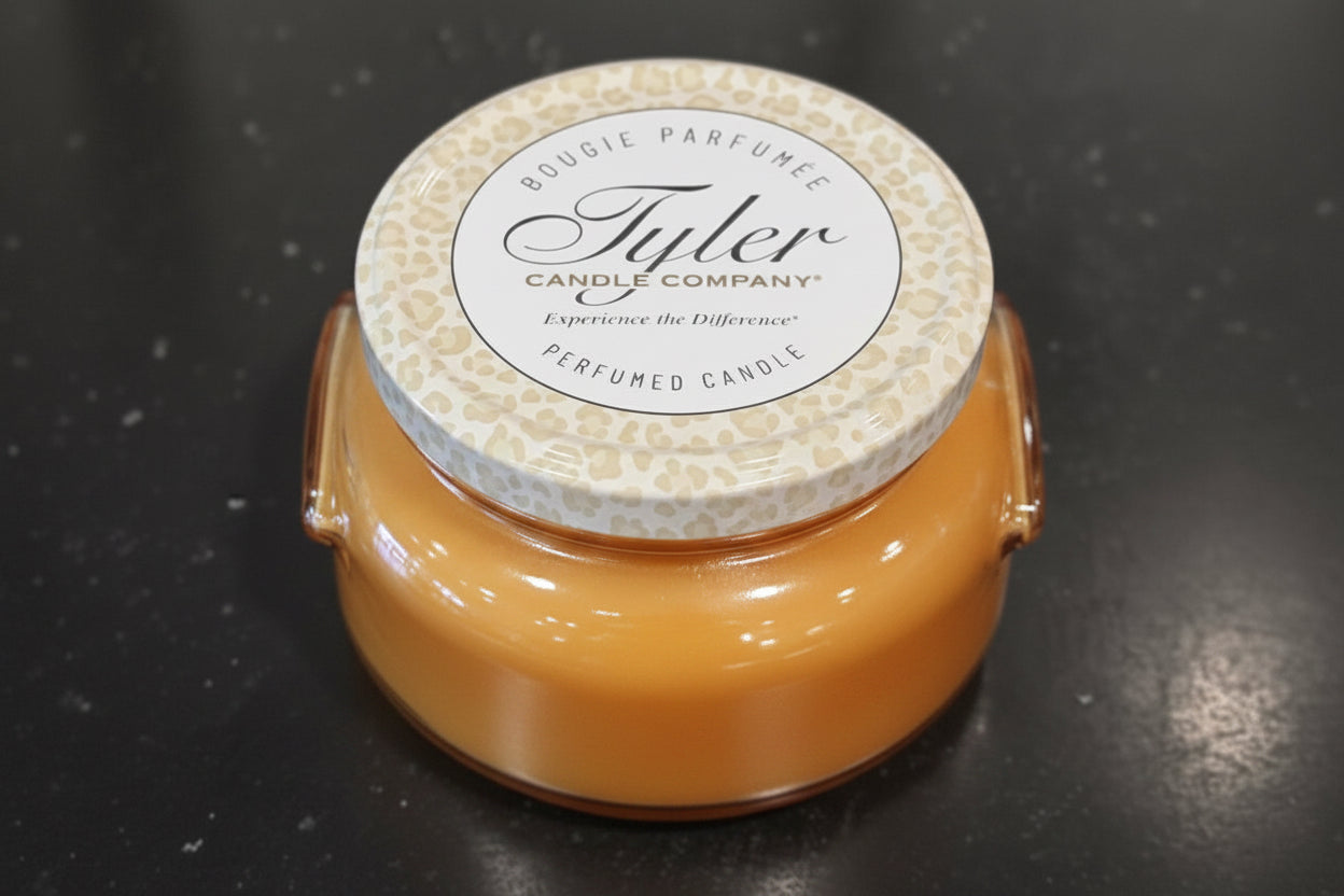 Tyler candle with a patterned lid on a dark surface