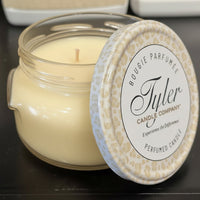 Tyler Candle Company candle with a decorative lid on a dark surface