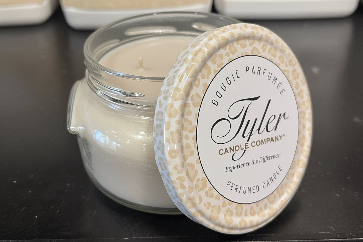 Tyler candle in a glass jar with a decorative lid on a dark surface