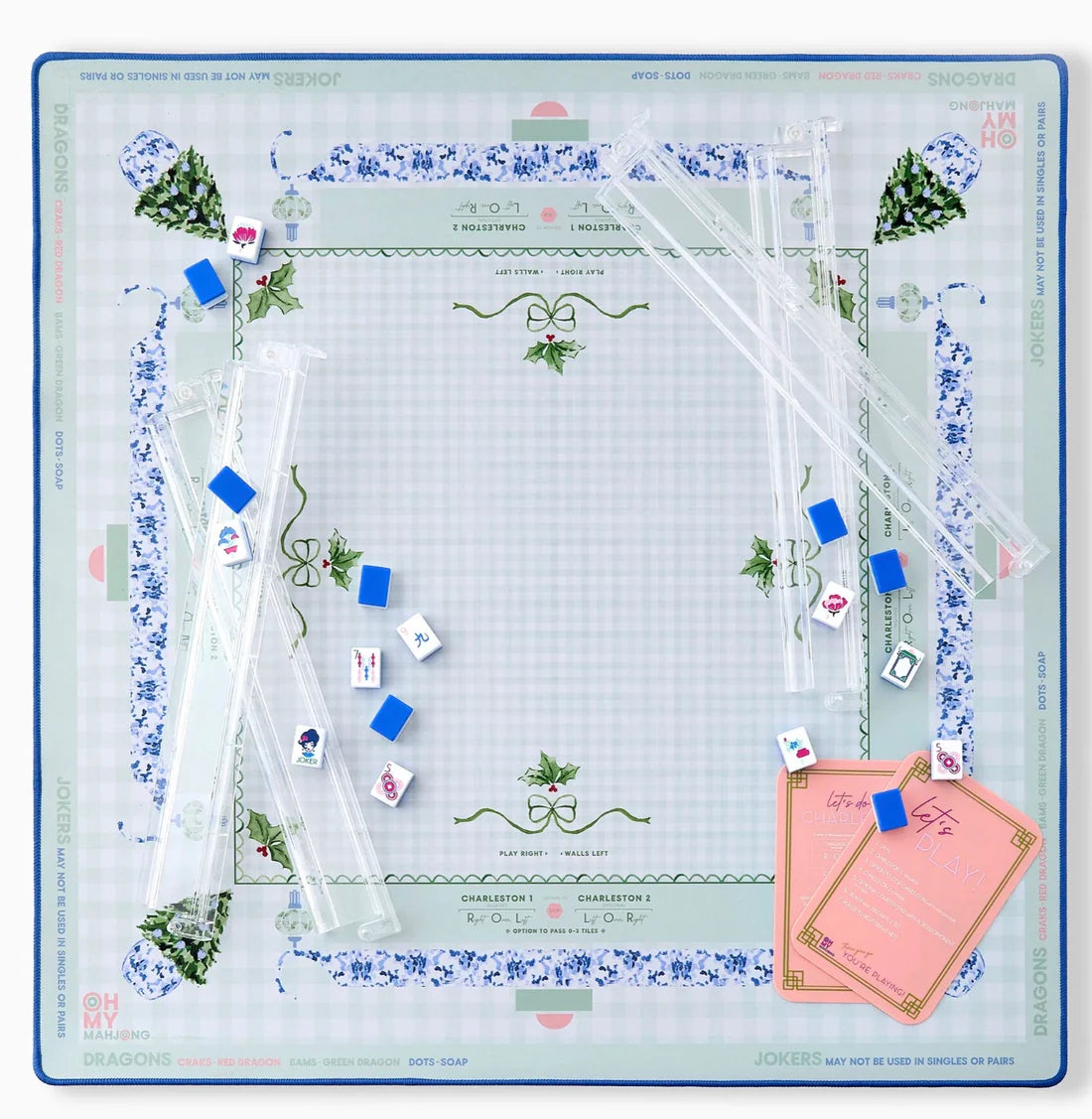 A square mahjong mat laid out flat on a white background. The board has a pale green and white grid pattern with a blue border, blue floral accents, green vine motifs, and small illustrated characters.
