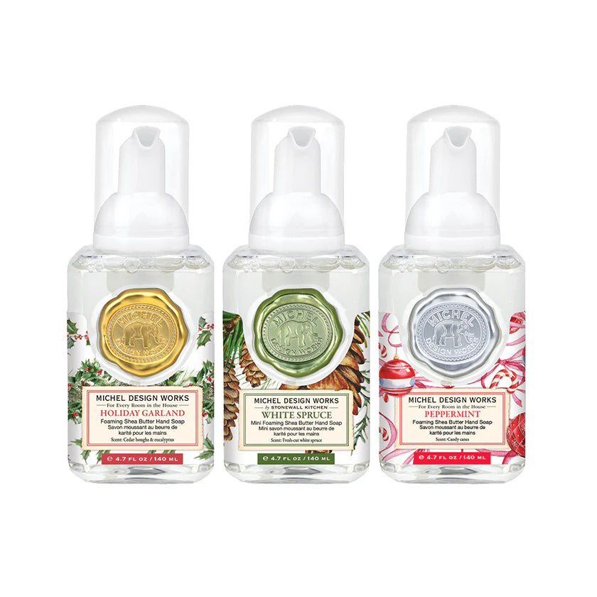 Three bottles of Michel Design Works hand soap with different scents on a white background
