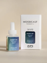 Moodcast fragrance bottle and packaging on a beige background