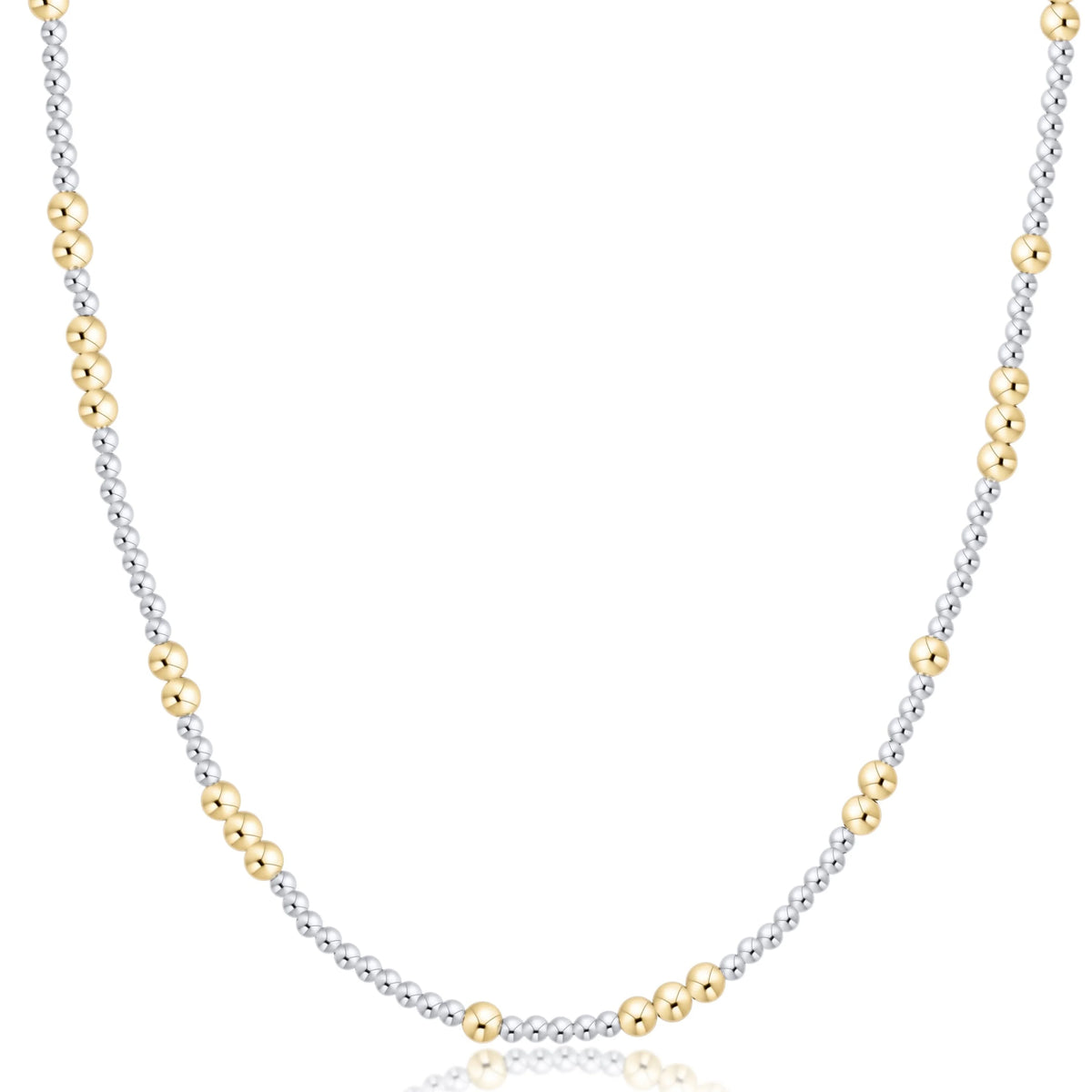 A delicate two-tone necklace featuring a silver-toned beaded chain accented with small gold-toned beads, displayed on a clean white background with a subtle reflection.