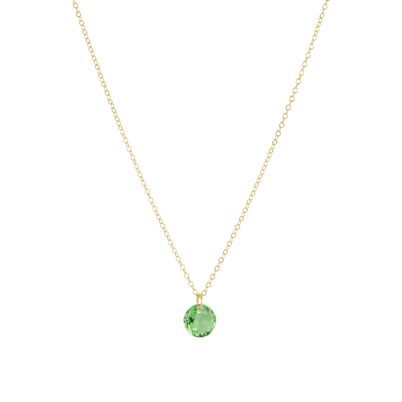 Gold necklace with a green gemstone pendant on a white background