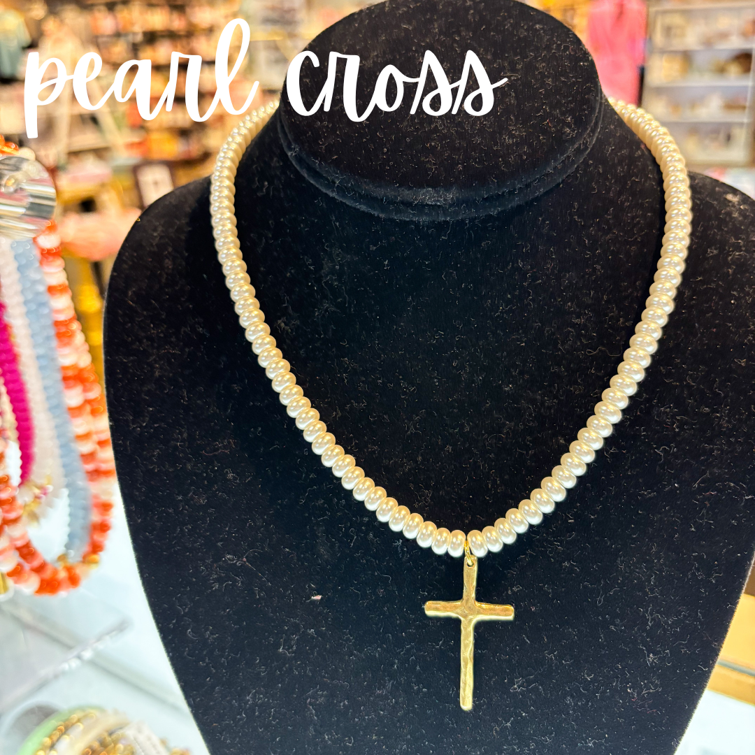 Pearl necklace with a gold cross pendant on a black velvet stand, with 'pearl cross' text above.