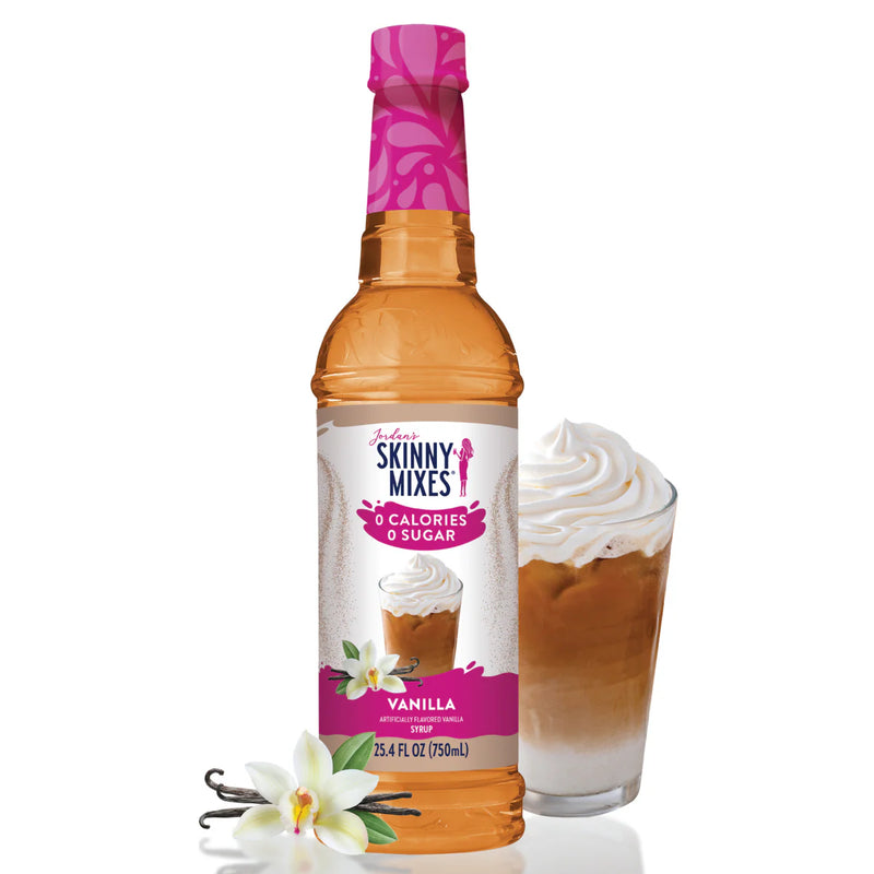 Bottle of Skinny Mixes vanilla syrup with a glass of dessert and vanilla flowers on a white background