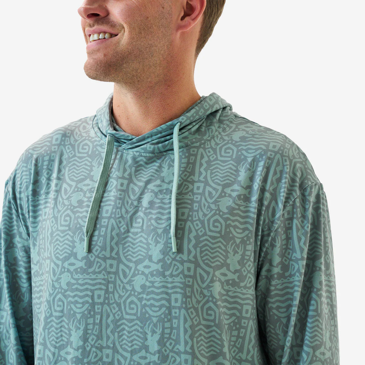 Man wearing a patterned teal hoodie on a white background