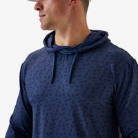 Man wearing a blue patterned hoodie against a plain background