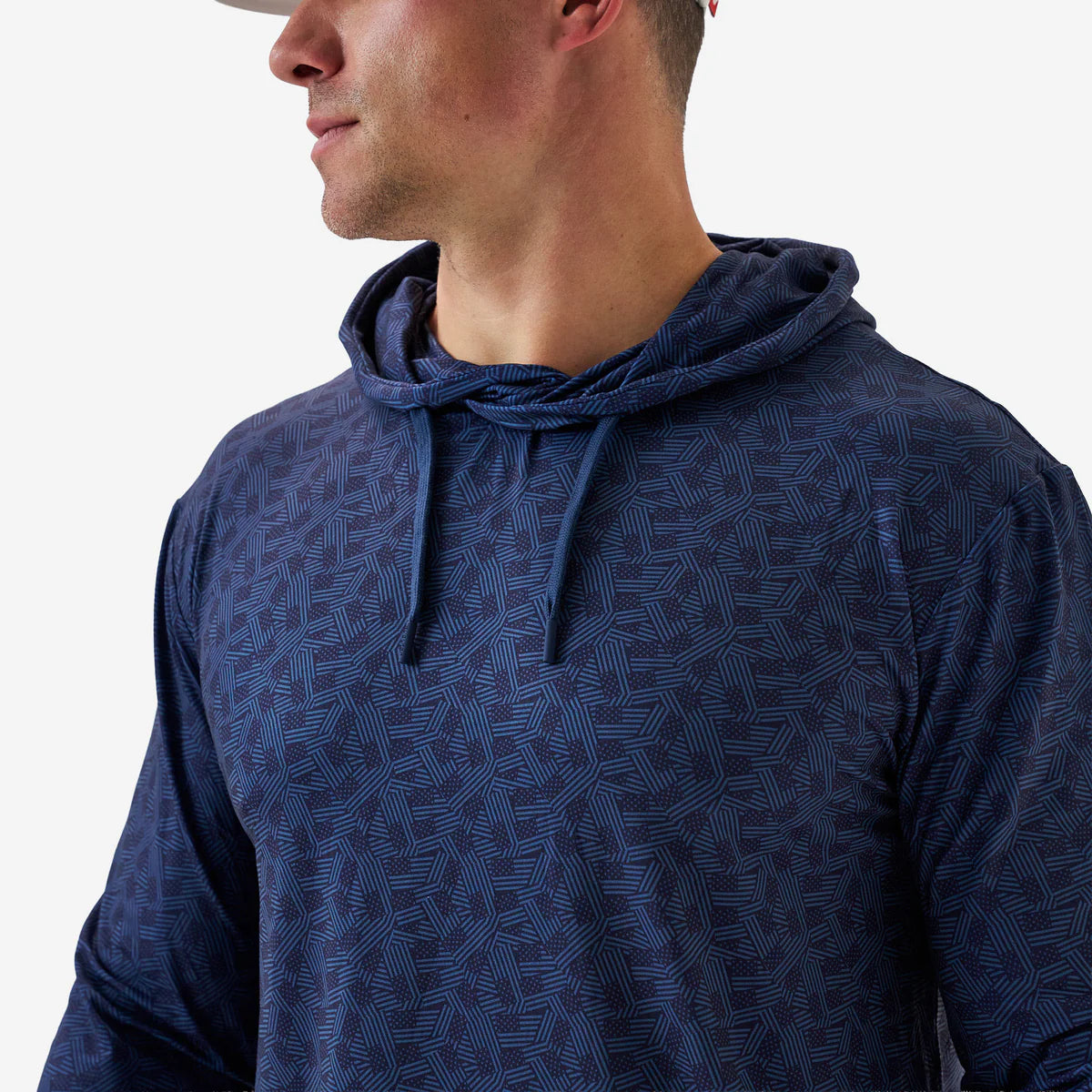 Man wearing a blue patterned hoodie against a plain background