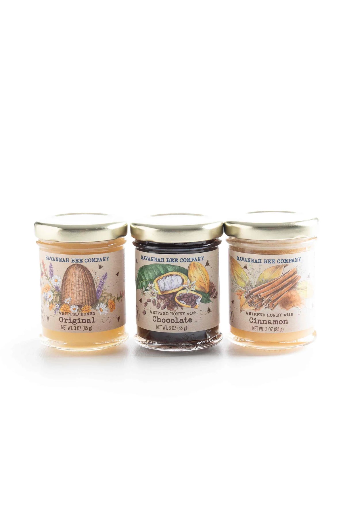 Three jars of honey with different flavors on a white background