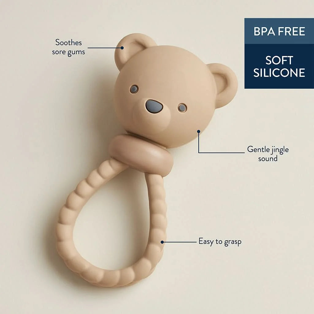 A beige silicone baby teether shaped like a teddy bear head with a textured ring handle, shown on a plain beige background.