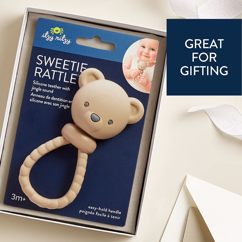 A beige silicone baby teether shaped like a teddy bear head with a textured ring handle, shown on a neural background.