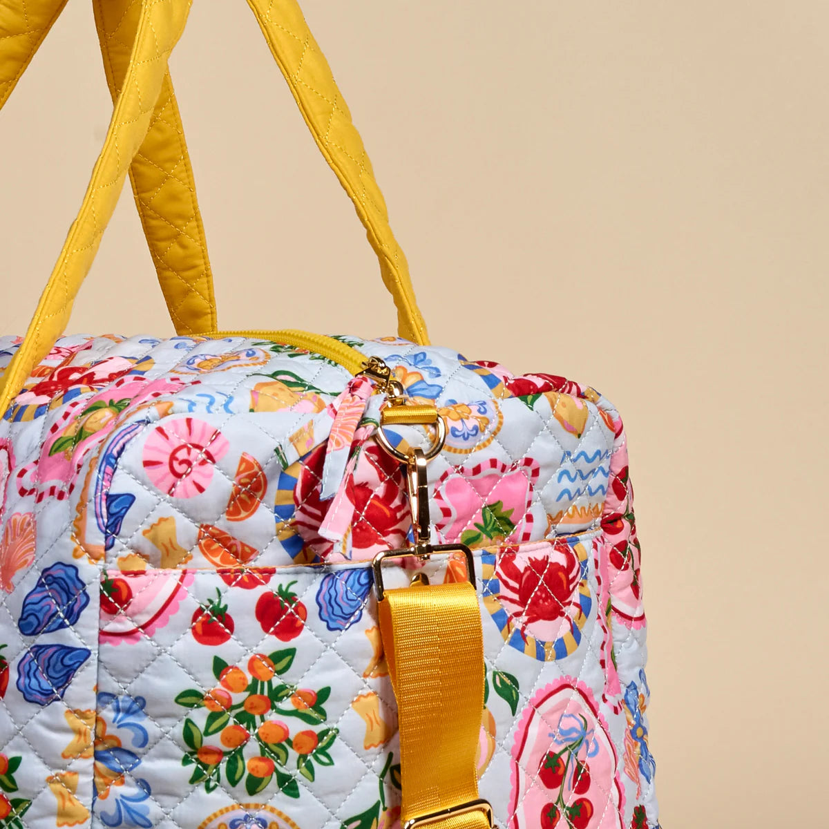 Colorful quilted bag with floral and fruit pattern on a beige background