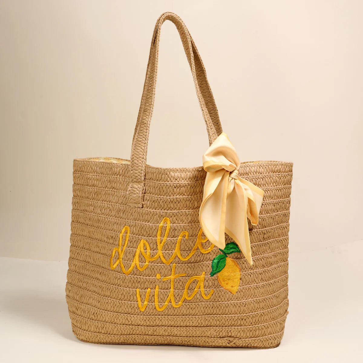 Woven bag with 'dolce vita' embroidery and lemon design on a beige background
