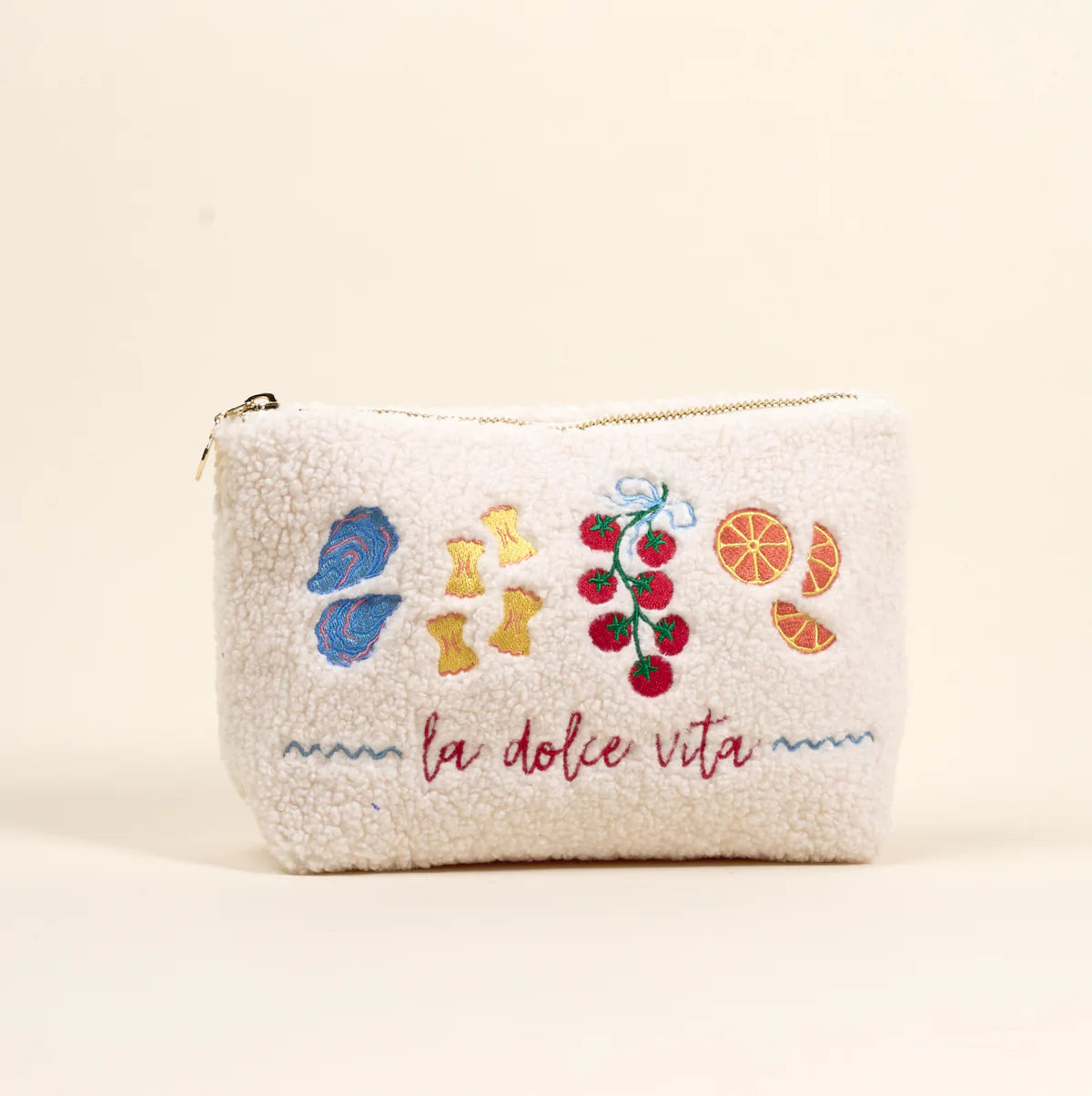 Small pouch with embroidered designs and 'la dolce vita' text on a beige background