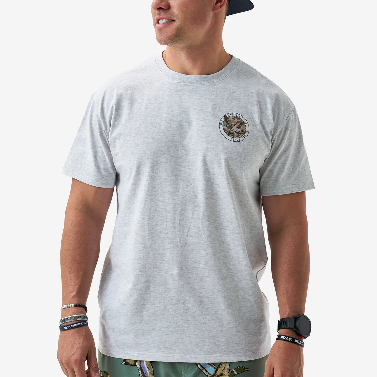 Man wearing a gray t-shirt with a logo on a white background