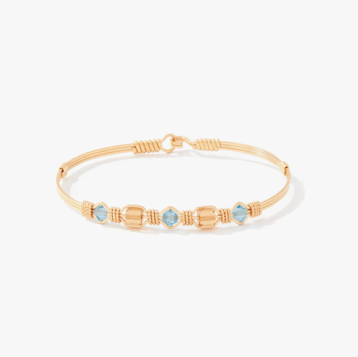 Gold bracelet with blue gemstones on a white background