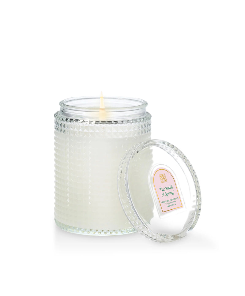 Glass candle with a beaded design and a label on a white background