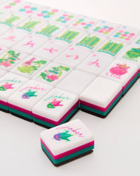 Decorative Mahjong tiles with colorful designs and text on a white surface