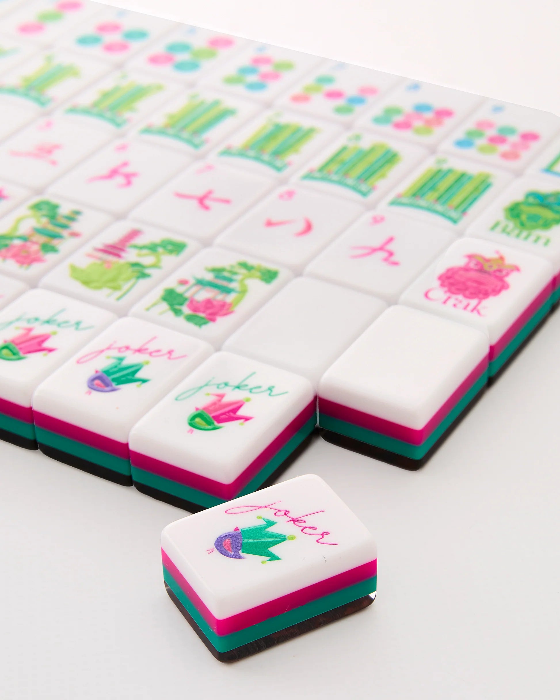 Decorative Mahjong tiles with colorful designs and text on a white surface