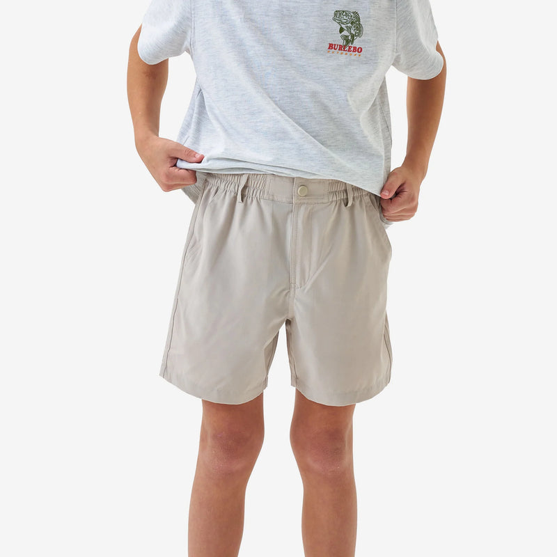Person wearing beige shorts and a white t-shirt with a logo on a white background