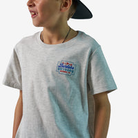 Child wearing a gray t-shirt with a logo on a white background