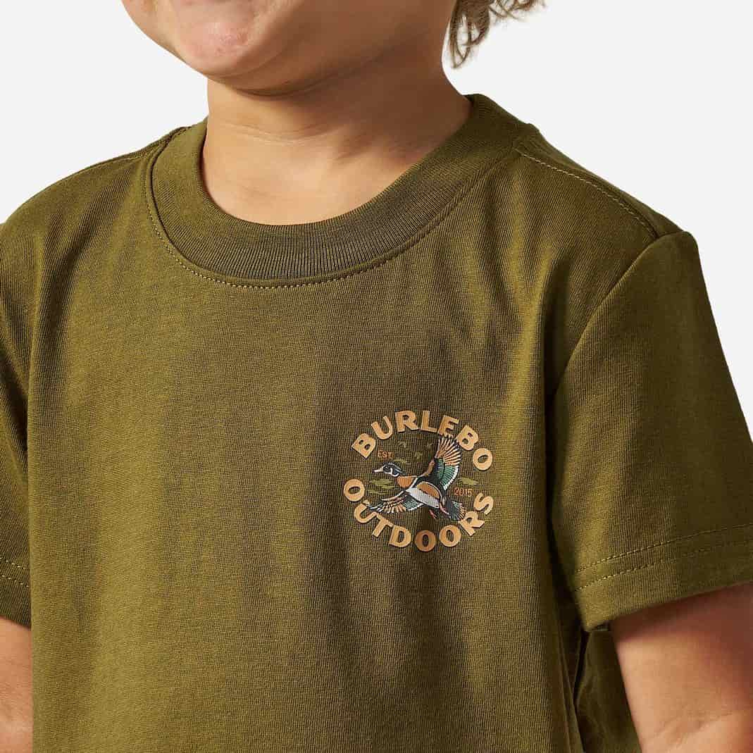 A close-up of a child wearing an olive green short-sleeve t-shirt with a circular 'BURLEBO OUTDOORS' duck logo printed on the left chest.