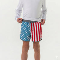 Person wearing American flag patterned shorts on a white background