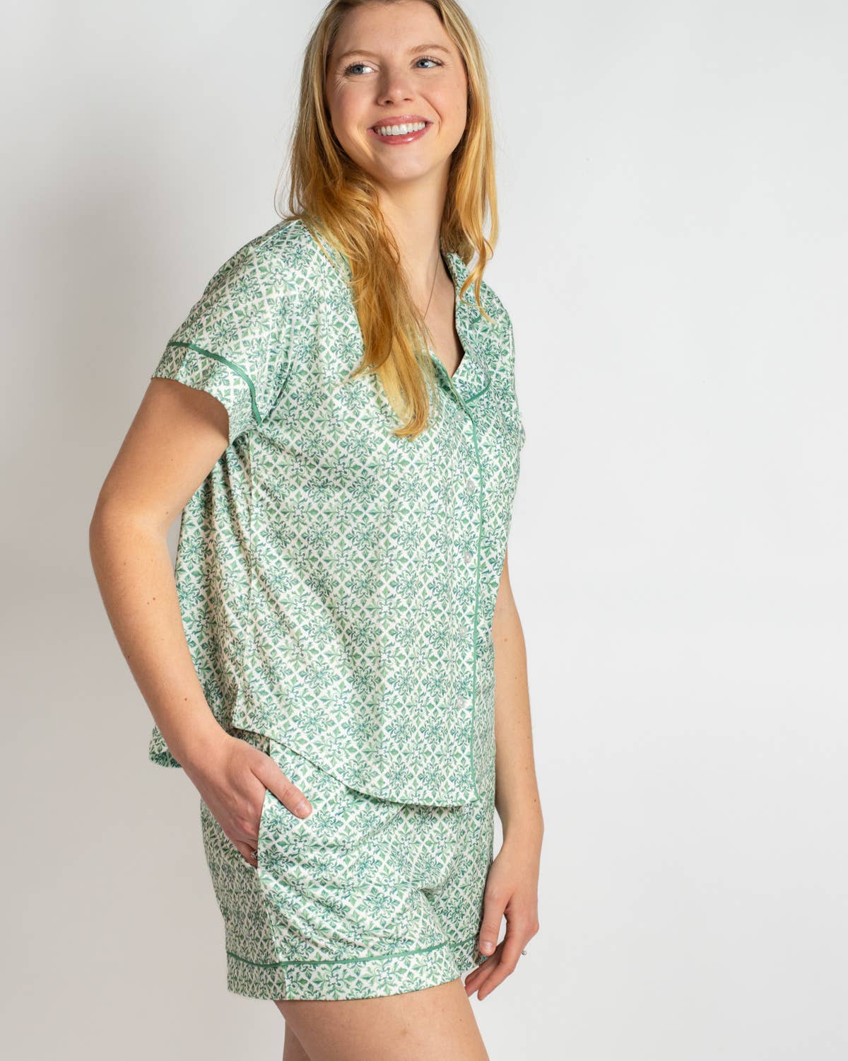 Woman wearing a green patterned nightshirt on a plain background