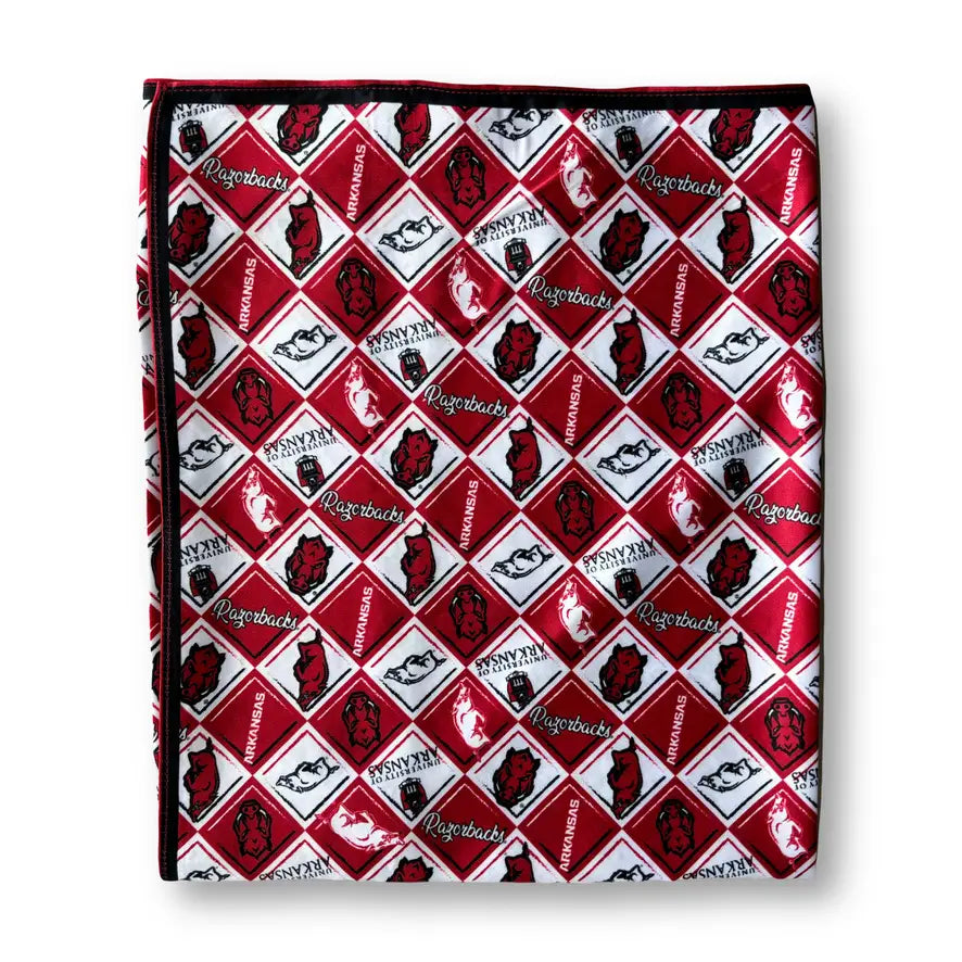 A folded square fabric item, likely a scarf or pocket square, featuring a repeating red, white, and black diamond pattern with the word 'Nougats' and a stylized cat logo.