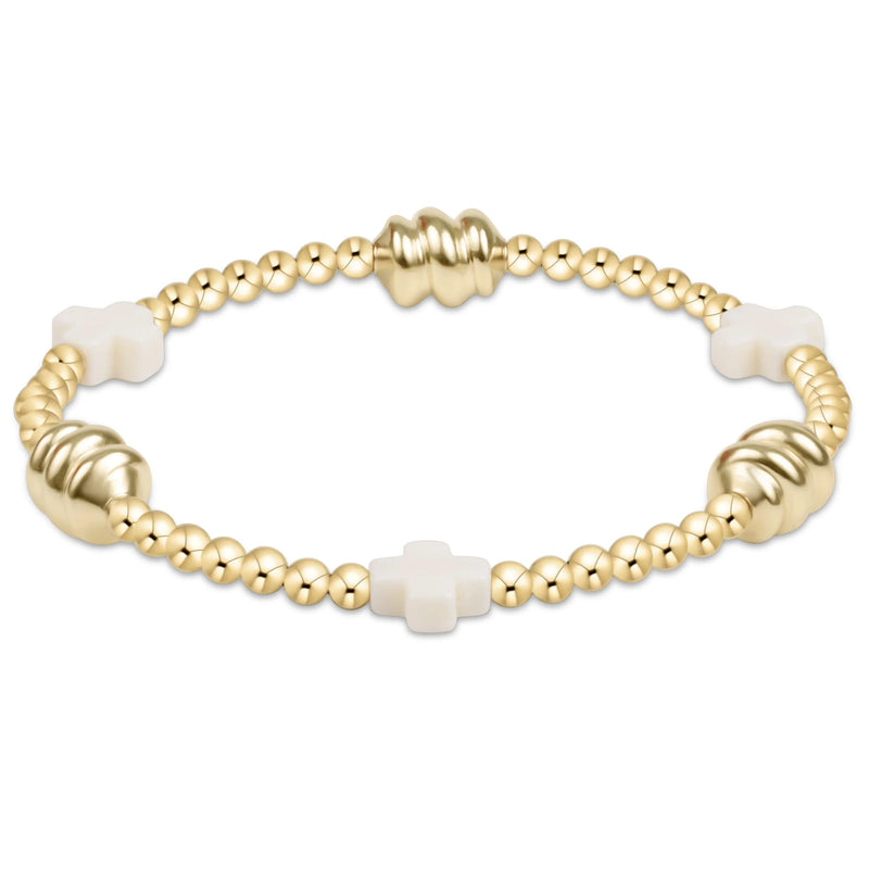 Gold bracelet with white beads on a white background

