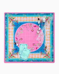 A square mahjong mat featuring a vibrant pink central circle with floral motifs, surrounded by a blue border, a white lattice grid, and a turquoise outer frame with gold accents and botanical details.