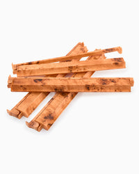 A set of natural Mahjong rack and pushers with prominent figured burl wood grain, arranged in a crossed stack on a plain white background.
