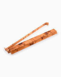 A set of natural Mahjong rack and pusher with prominent figured burl wood grain, arranged in a crossed stack on a plain white background.