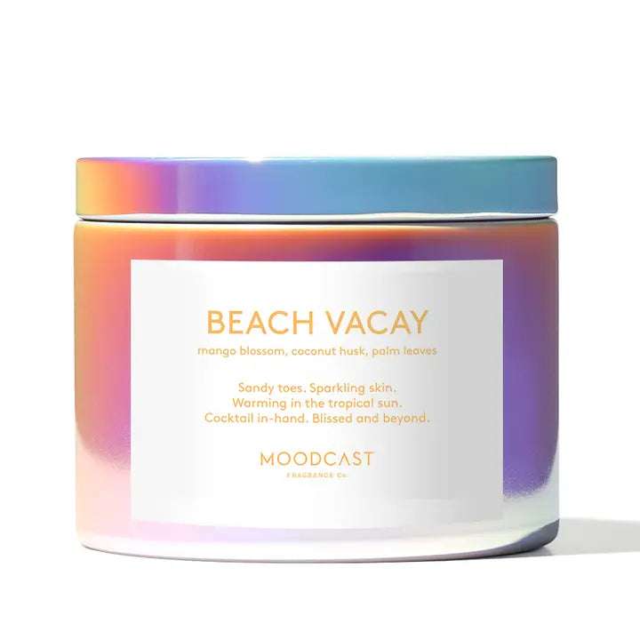 Candle with 'Beach Vacay' label and colorful lid on a white background