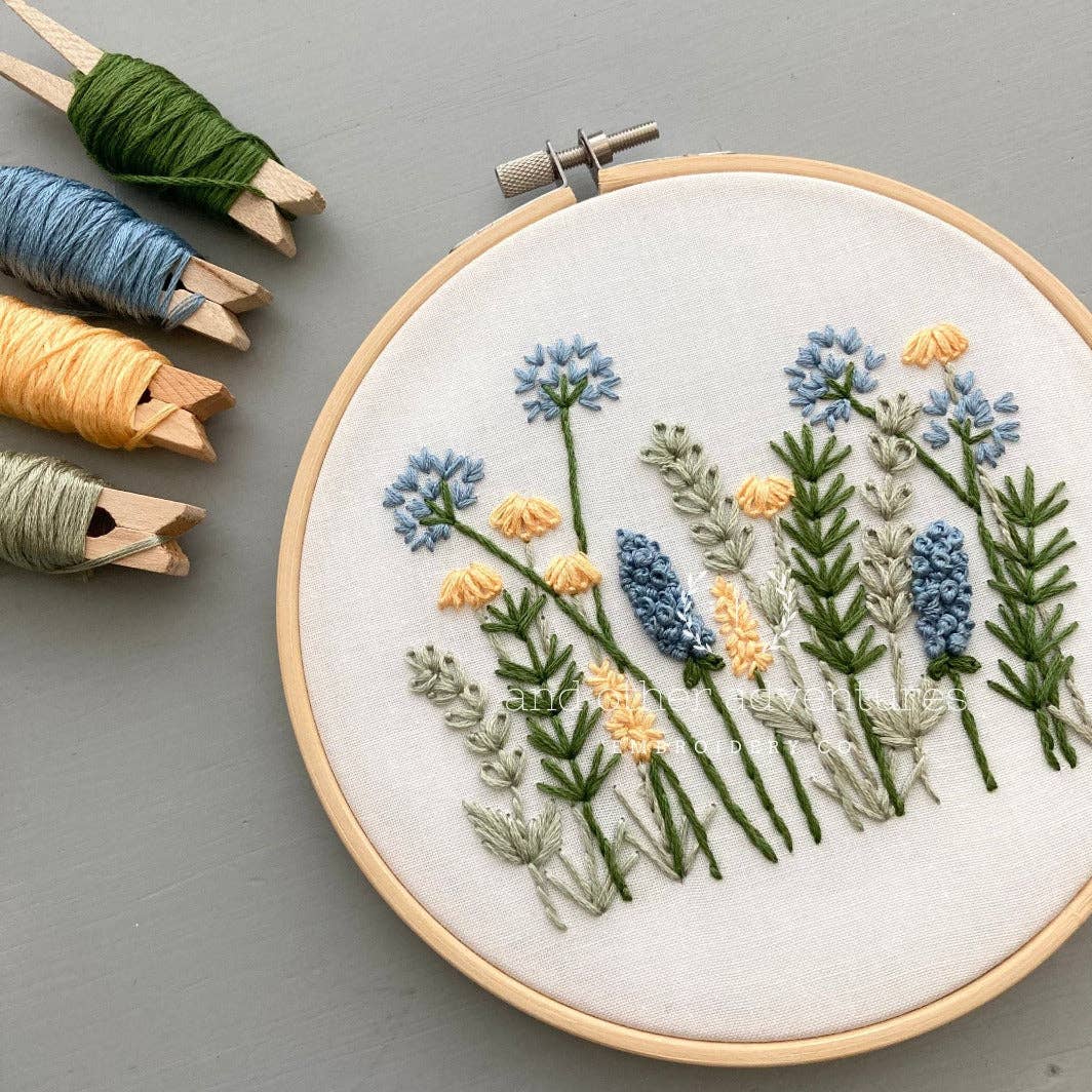 Embroidery hoop with floral embroidery on a gray background
