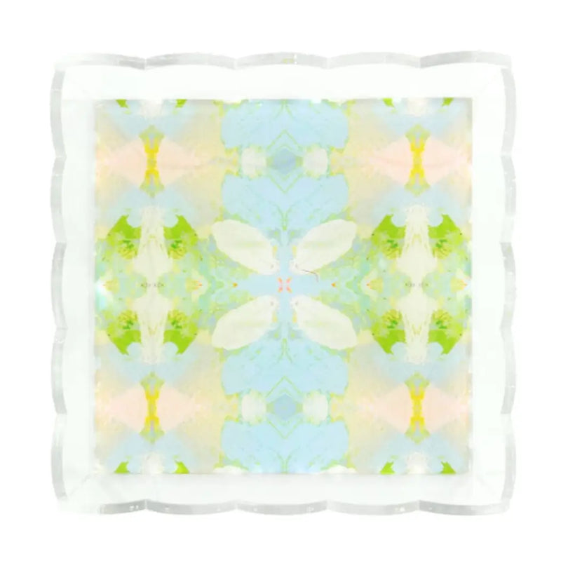A square decorative tray with a scalloped clear plastic rim and a pastel abstract mirrored pattern in light blue, mint green, cream, and soft pink on a white background.