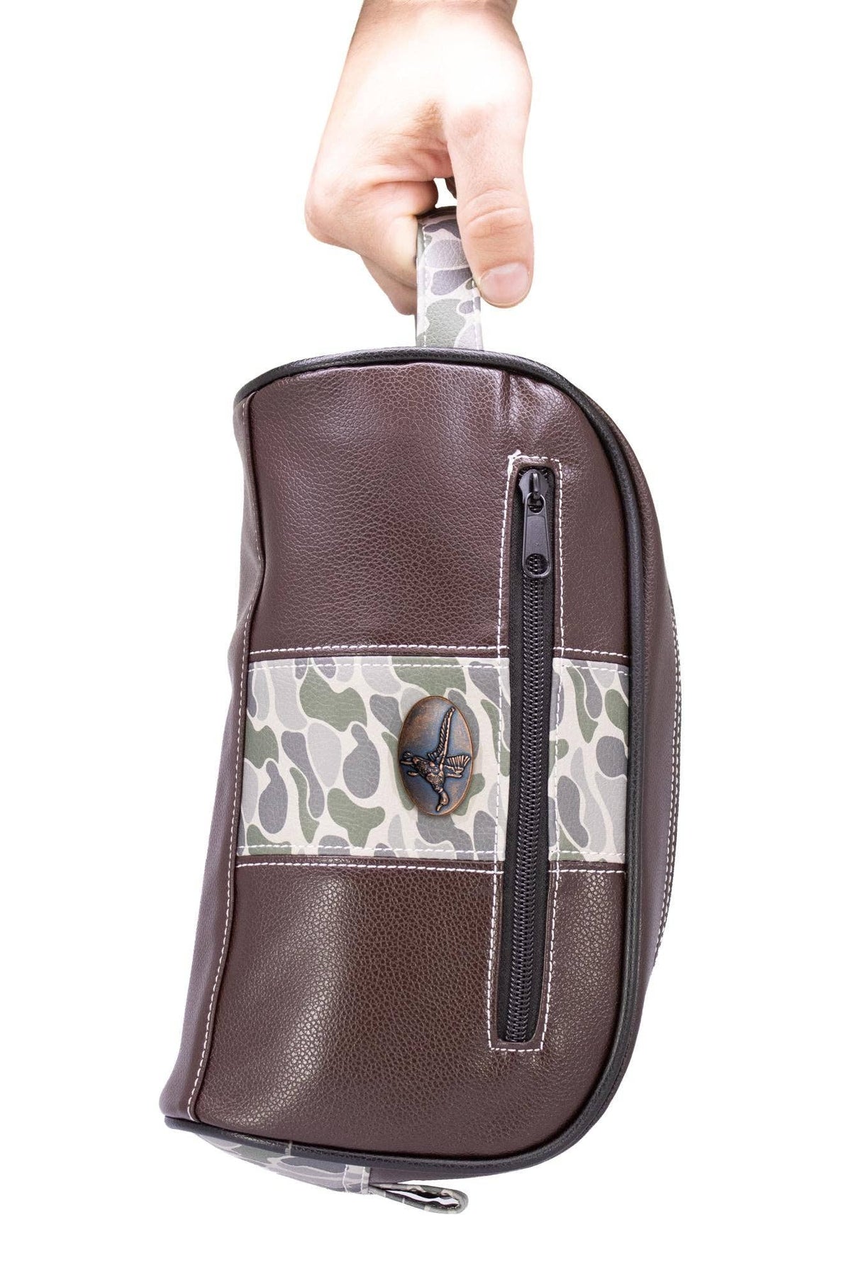 Brown leather pouch with camouflage pattern held by a hand on a white background