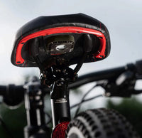 Close-up of a bicycle seat with red accents on a blurred background