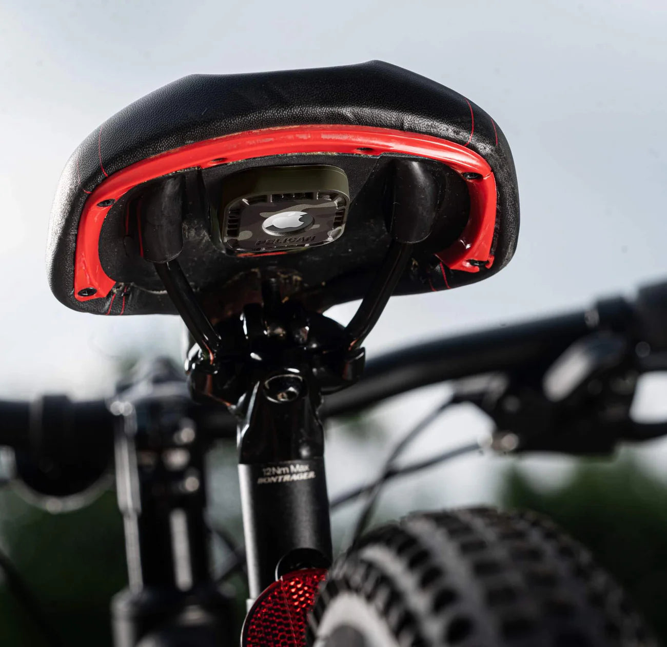 Close-up of a bicycle seat with red accents on a blurred background