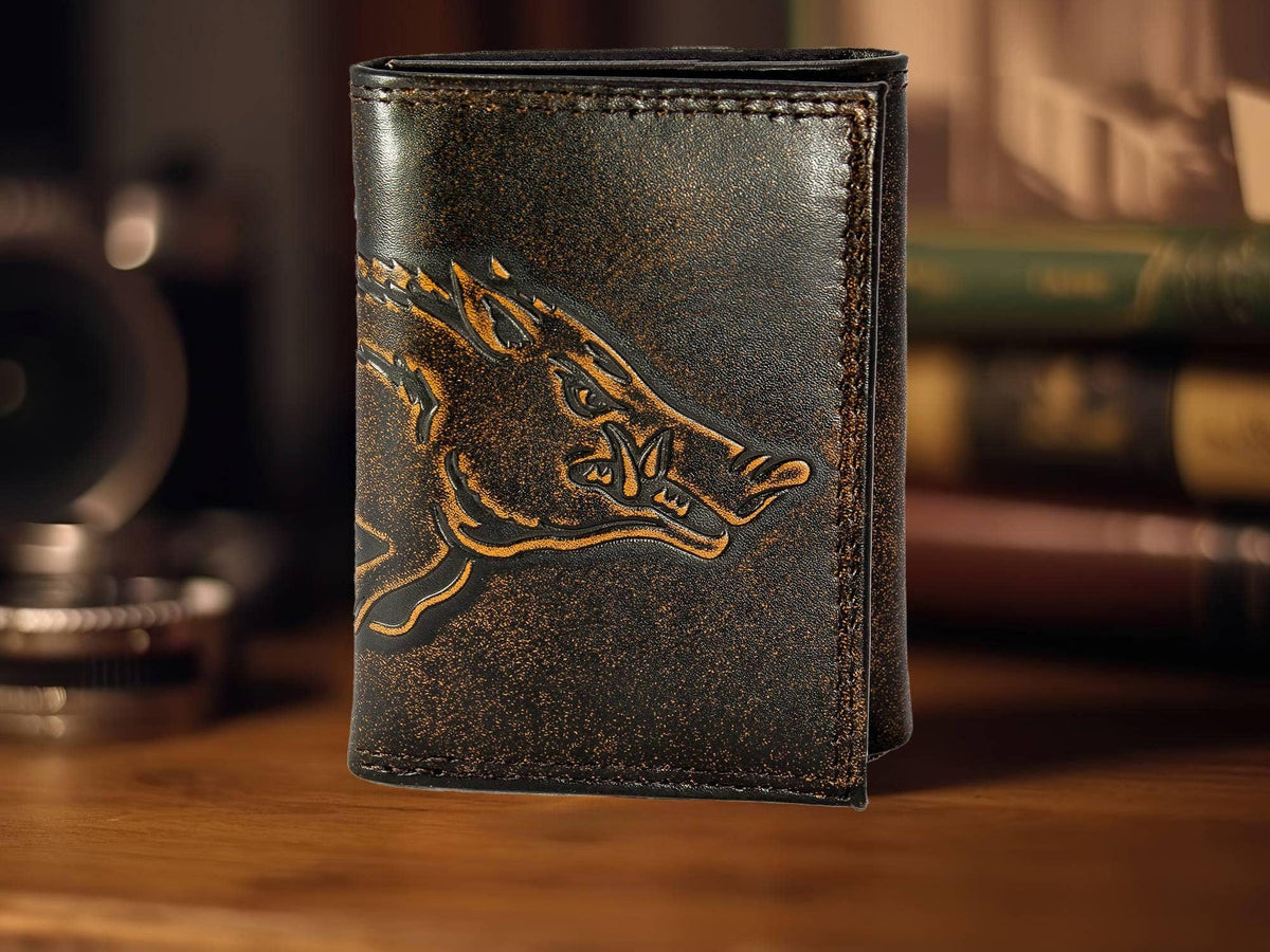Brown leather wallet with embossed design on a wooden surface