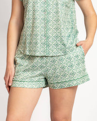 Green and white patterned pajama set on a plain background