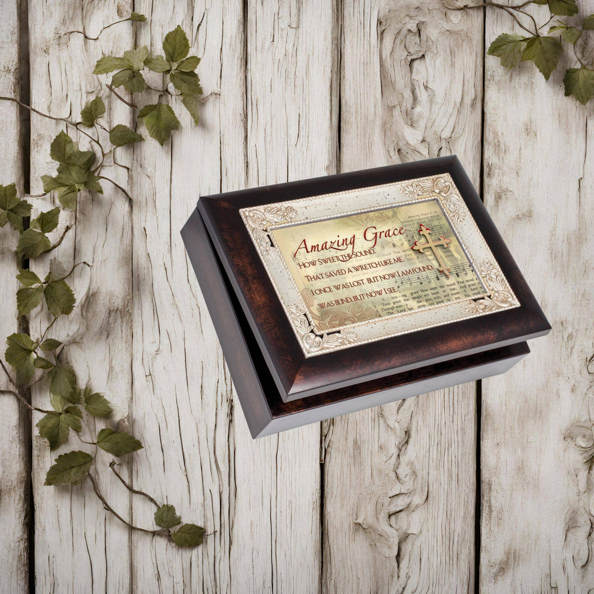 Decorative box with 'Amazing Grace' text on a wooden surface with green leaves.